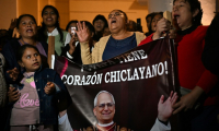Des personnes chantent à côté de l'image de Robert  Prevost, devenu le pape Léon XIV, à Chiclayo, au Pérou, le 8 mai 2025 ( AFP / ERNESTO BENAVIDES )