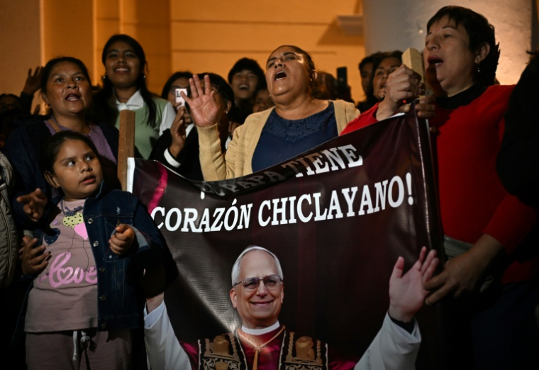 Des personnes chantent à côté de l'image de Robert Prevost, devenu le pape Léon XIV, à Chiclayo, au Pérou, le 8 mai 2025 ( AFP / ERNESTO BENAVIDES )