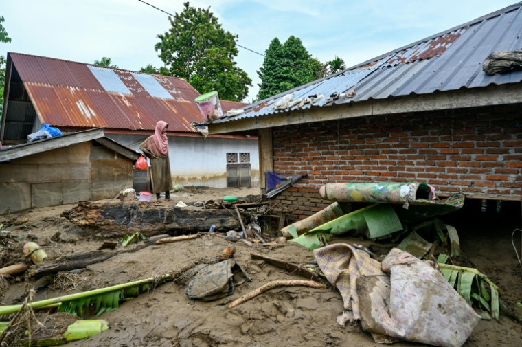 Une femme observe sa maison inondée à la suite de crues soudaines à Meureudu, dans la province d’Aceh, en Indonésie, le 28 novembre 2025 ( AFP / CHAIDEER MAHYUDDIN )