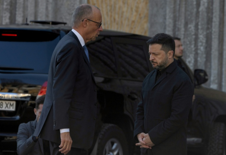Le président ukrainien Volodymyr Zelensky (D) et le chancelier allemand Friedrich Merz (G) lors d'une visite du bâtiment endommagé de l'Académie des sciences de Kiev, le 4 octobre 2026  ( AFP / Tetiana DZHAFAROVA )