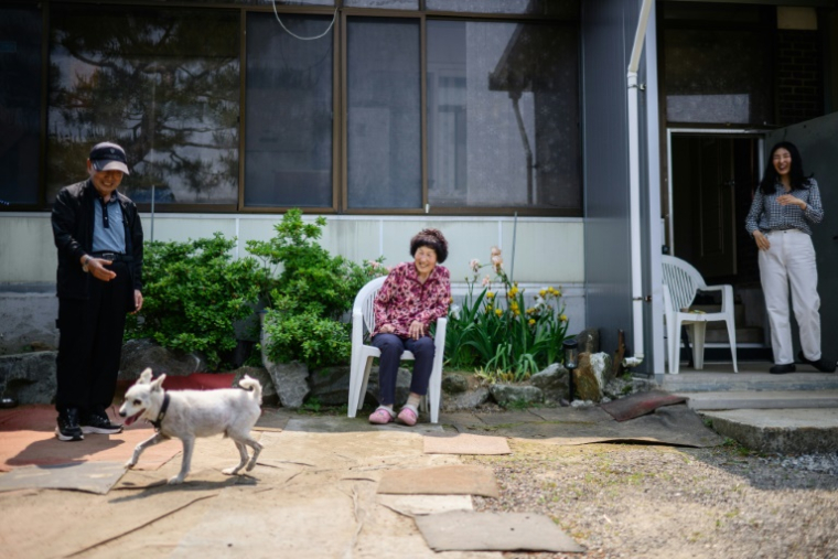 De gauche à droite, Min Tae-sung, 87 ans, son épouse Park Ok-mi, 78 ans et leur fille Min Sung-hee, 45 ans, dans leur maison familiale du village de Tongilchon, voisin de la Corée du Nord, 28 mai 2025 ( AFP / ANTHONY WALLACE )