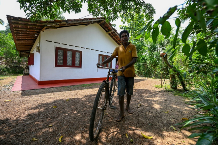 W.D. Jayaratne, chef de l'association locale des agriculteurs, devant chez lui à Waturawela, le 28 mars 2025 au Sri Lanka ( AFP / Ishara S. KODIKARA )