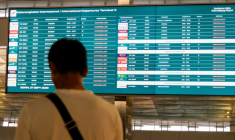 Un passager bloqué à l'aéroport international Soekarno-Hatta en raison de l'éruption du volcan Anak Krakatau, regarde un écran d'information sur les vols, le 7 septembre 2026 à Tangerang, en Indonésie ( AFP / Taris HIRZIMAN )