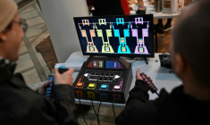 Des personnes jouent à un jeu vidéo fabriqué à partir de composants électroniques recyclés lors de la 3e Rencontre fédérale Cyberciruja à Buenos Aires, le 16 août 2025 en Argentine ( AFP / Luis ROBAYO )