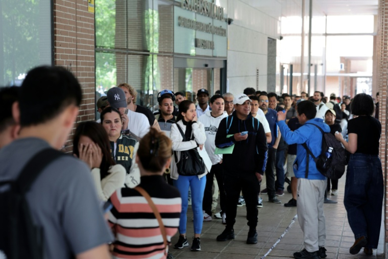 Des personnes font la queue pour entrer dans les locaux de la Commission espagnole d'aide aux réfugiés (CEAR) à Madrid, en Espagne, le 22 avril 2026 ( AFP / Thomas COEX )