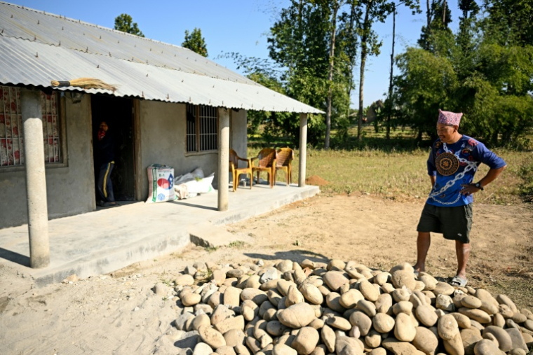 Dipak Magar devant la maison qu'il a construite avec l'argent gagné à l'étranger, le 12 décembre 2025 à Madi, au Népal ( AFP / Prakash MATHEMA )