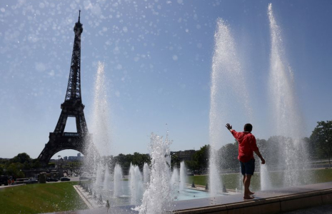 Un touriste se rafraîchit dans la fontaine du Trocadéro à côté de la Tour Eiffel alors qu'une vague de chaleur précoce frappe Paris