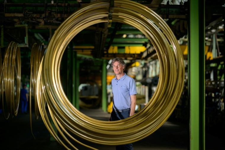 Le patron de MPG Tubes, Andreas Gahl, derrière une bobine de tubes lisses en alliages de cuivre, dans l'usine située à Menden, dans l'ouest de l'Allemagne, le 18 juin 2026 ( AFP / SASCHA SCHUERMANN )