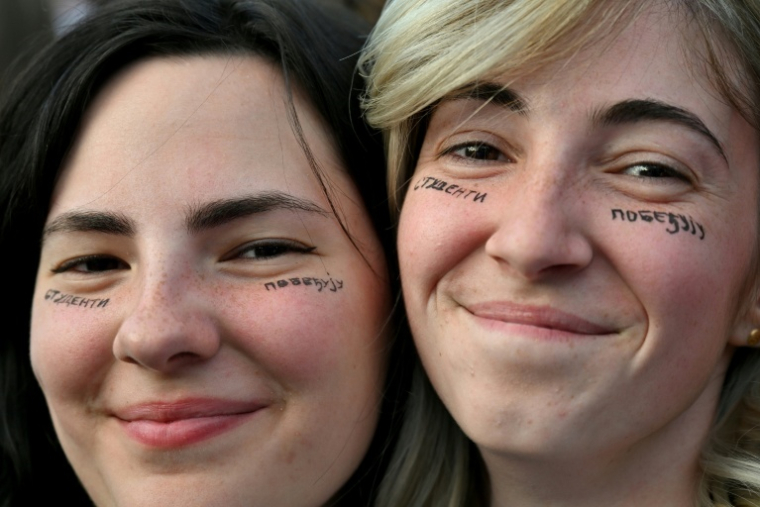 Deux jeunes manifestants avec le slogan "les étudiants gagnent" écrit sur les joues, lors d'un rassemblement contre le gouvernement à Belgrade, le 23  mai 2026 ( AFP / Andrej ISAKOVIC )