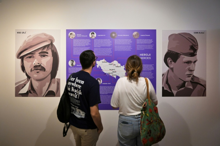 Des visiteurs pendant l'exposition "Labyrinthe des années 90 : à la découverte des Balkans", dans une galerie à Belgrade, en Serbie, le 18 juin 2025 ( AFP / OLIVER BUNIC )