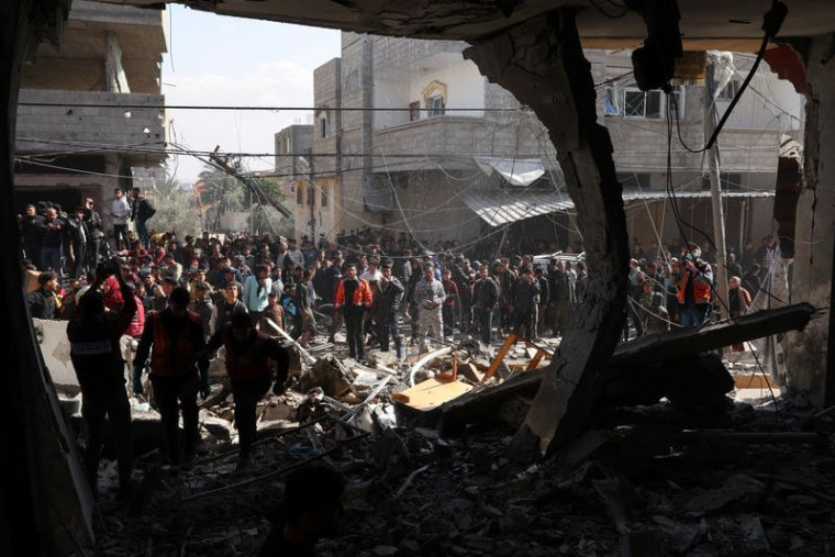 Des Palestiniens se rassemblent sur le site d'une frappe israélienne à Rafah, dans le sud de Gaza