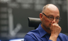 Un trader réagit à son bureau devant le tableau du DAX à la bourse de Francfort