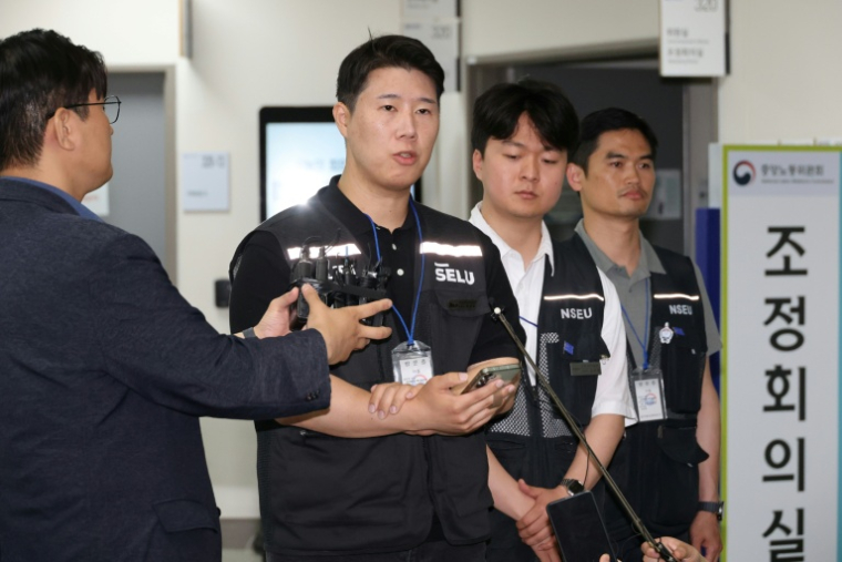 Choi Seung-ho (au centre), président du syndicat de Samsung Electronics, s'adresse aux journalistes à Sejong, en Corée du sud, le 20 mai 2026 ( YONHAP / - )