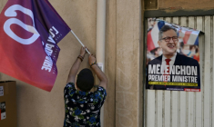 Un drapeau de la France insoumise (LFI) et une affiche électorale montrant Jean-Luc Mélenchon à Marseille, le 12 mai 2022 ( AFP / Pascal GUYOT )