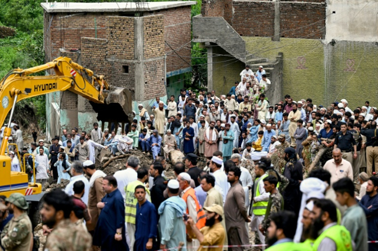 Des habitants regardent les secours fouiller les décombres des maisons effondrées à la recherche de victimes, un jour après une de mousson dans le village de Dalori, au Pakistan, le 19 août 2025 ( AFP / Aamir QURESHI )