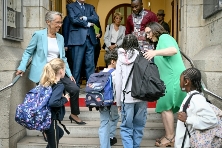 La ministre française de l'Éducation Elisabeth Borne (à gauche) accueille les élèves arrivant à l'école élémentaire publique Vigée-Lebrun le premier jour de classe après les vacances d'été, à Paris, le 1er septembre 2025 ( AFP / Bertrand GUAY )