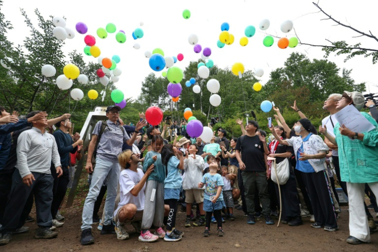Des proches des victimes de l'accident du vol 123 de Japan Airlines en 1985 lâchent des ballons sur le site du crash sur le mont Osutaka au Japon le 12 août 2025. ( JIJI Press / STR )
