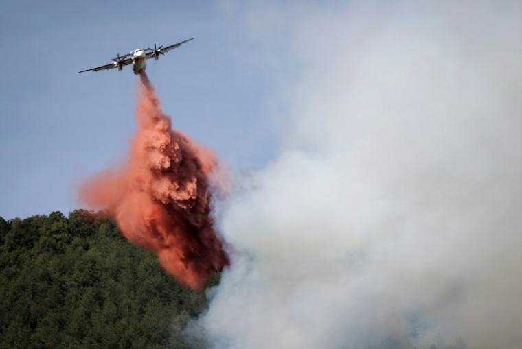 Un avion Bombardier Dash 8 Q400 MR largue du produit retardant sur un feu de forêt près de Puilaurens, le 5 septembre 2026 dans l'Aude ( AFP / Valentine CHAPUIS )