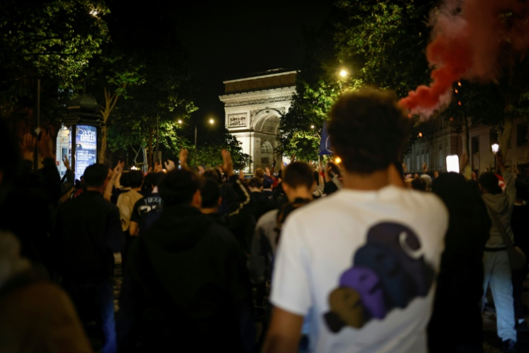 Des supporteurs du Paris Saint-Germain célèbrent la victoire après la qualification de leur équipe en finale de la Ligue des champions face au Bayern Munich, près de l'arc de Triomphe, le 6 mai 2026, à Paris ( AFP / SIMON WOHLFAHRT )