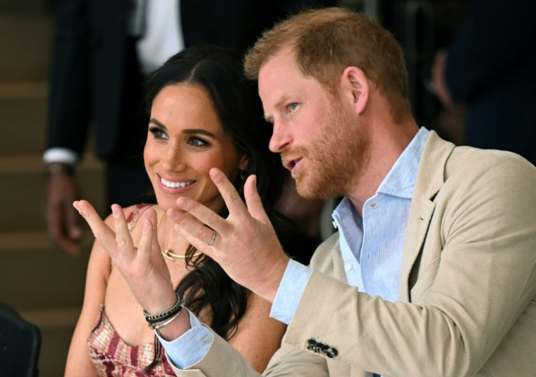 Le prince Harry (à droite), duc de Sussex, s'entretient avec son épouse Meghan Markle alors qu'ils assistent à un spectacle lors d'une visite au Centre national des arts de Bogota, le 15 août 2024. ( AFP / RAUL ARBOLEDA )