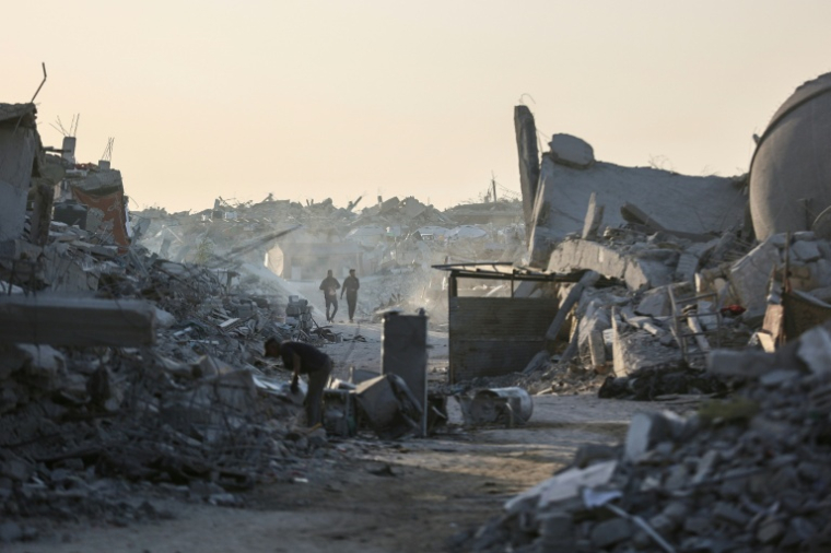 Des Palestiniens marchent au milieu des décombres dans le quartier de Cheikh Radouane, à Gaza-ville, le 22 octobre 2025 ( AFP / Omar AL-QATTAA )