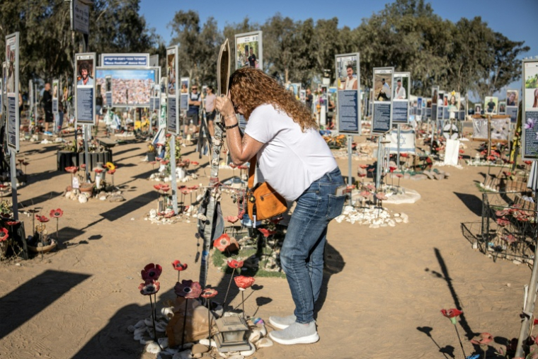 Une femme se recueille au mémorial dédiés aux victimes des attentats du 7 octobre 2023, sur le site du festival Nova à Reim, dans le sud d'Israël, à l'occasion du deuxième anniversaire des attaques, le 7 octobre 2025 ( AFP / JOHN WESSELS )