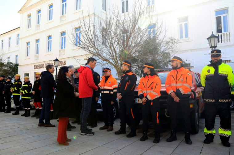Image fournie par les services du Premier ministre montrant Pedro Sanchez (c) qui salue les équipes d'urgence à San Roque (sud), le 6 février 2026 secourant la population face aux risques d'inondations après de violentes intempéries ( LA MONCLOA / Handout )