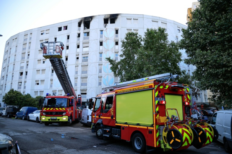 Des véhicules de pompiers stationnés devant un bâtiment où un incendie criminel a fait sept morts dans la nuit, le 18 juillet 2024 à Nice ( AFP / Valery HACHE )