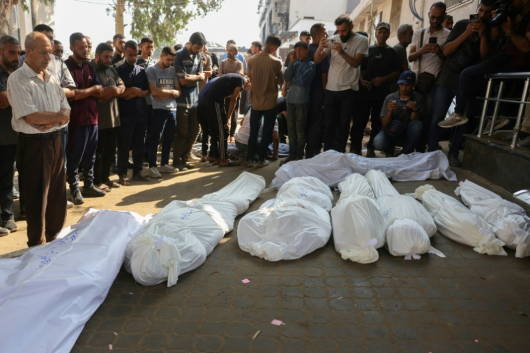 Des Palestiniens prient près des corps de membres de la famille Al-Chaer, dont une femme enceinte, tués selon la Défense civile dans une frappe israélienne sur leur maison à Gaza-ville, lors de leurs funérailles à l'hôpital Al-Chifa, le 23 juillet 2025 ( AFP / BASHAR TALEB )