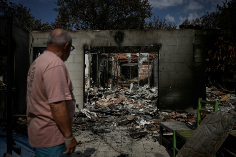 Yves Brugieregarde regarde sa maison détruite par le mégafeu de juillet, le 13 août 2026 au Porge, en Gironde ( AFP / Philippe LOPEZ )