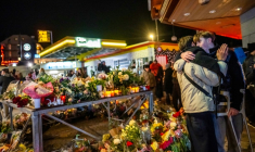 Un survivant blessé (à droite) enlace un proche près d'un mémorial improvisé après un incendie dans un bar qui a fait 40 morts et plus de 100 blessés au nouvel an, à Crans-Montana (Suisse) le 2 janvier 2026 ( AFP / MAXIME SCHMID )