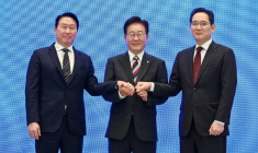 Le président Lee Jae Myung (c) scelle d'une poignée de main un plan public-privé de 1.200 milliards de dollars pour les puces et l'IA, à Séoul, le 29 juin 2026 ( POOL / KIM Min-Hee )