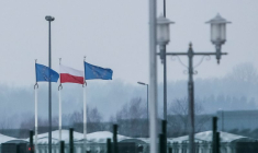 Une vue sur la frontière biélorusse-polonaise montre des drapeaux polonais et européens derrière une clôture