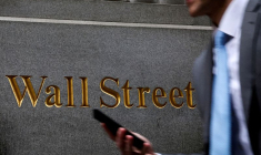 Un homme marche sur Wall Street devant le NYSE à New York