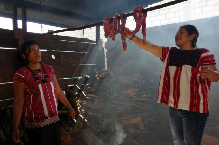 Une femme membre de la communauté indigène Tseltal prépare de la viande fumée qui sera conservée hors de la chaîne du froid faute de réfrigérateur à Oxchuc, Etat du Chiapas, dans le sud du Mexique, le 7 mai 2025 ( AFP / Raul VERA )