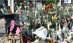 Une photo de Mélanie, la surveillante tuée par un élève, placée à côté des fleurs déposées devant les grilles du collège Françoise-Dolto, le 13 juin 2025 à Nogent, en Haute-Marne ( AFP / FRANCOIS NASCIMBENI )