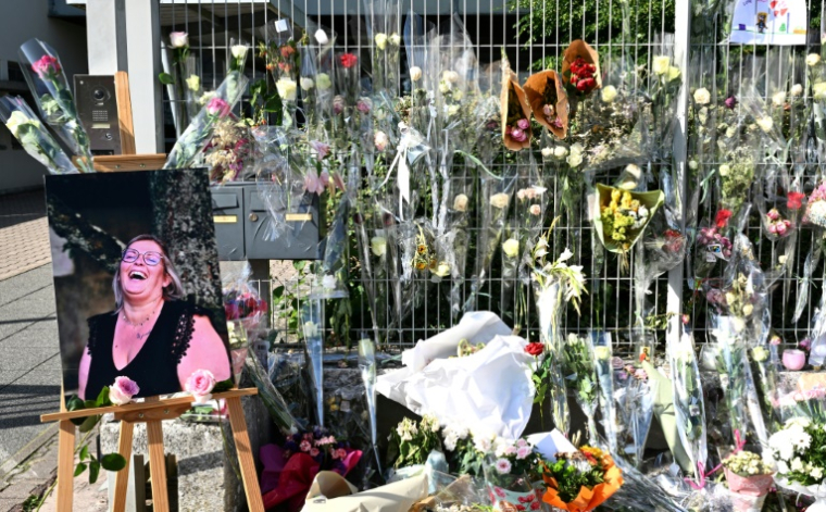 Une photo de Mélanie, la surveillante tuée par un élève, placée à côté des fleurs déposées devant les grilles du collège Françoise-Dolto, le 13 juin 2025 à Nogent, en Haute-Marne ( AFP / FRANCOIS NASCIMBENI )