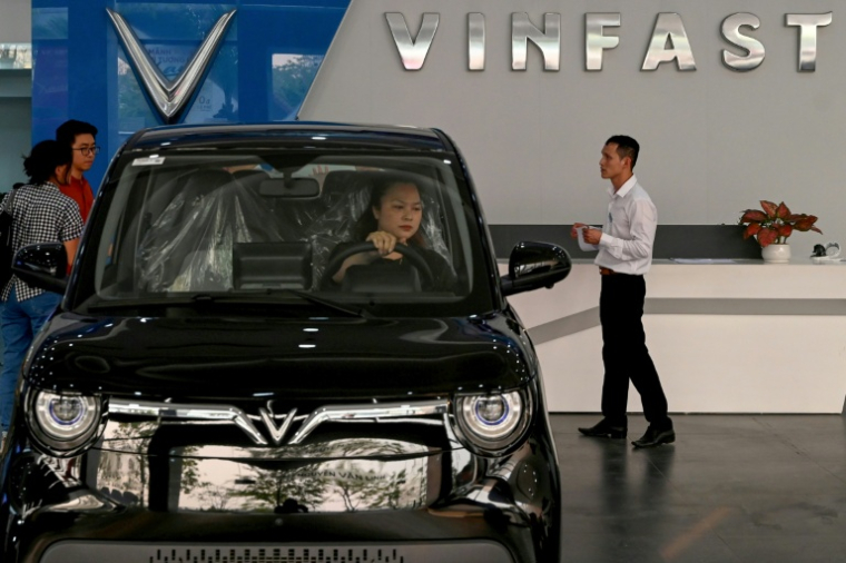 Une femme au volant d'une voiture chez le concessionnaire de voitures électriques Vinfast à Hanoï, le 11 avril 2026 au Vietnam ( AFP / Nhac NGUYEN )