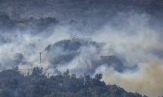 De la fumée s'élève dans une zone boisée en proie à un incendie au sud de la ville de Réthymnon, sur l'île grecque de Crète, le 30 juillet 2026 ( AFP / Costas METAXAKIS )