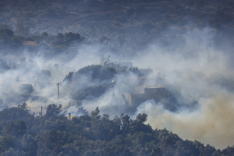 De la fumée s'élève dans une zone boisée en proie à un incendie au sud de la ville de Réthymnon, sur l'île grecque de Crète, le 30 juillet 2026 ( AFP / Costas METAXAKIS )