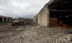 Des membres des services ukrainiens marchent vers un véhicule blindé de transport de troupes russe précédemment capturé dans le village de Blahodatne, dans la région de Kherson