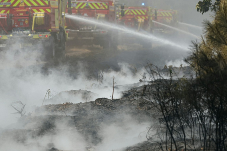 Des pompiers effectuent des opérations de noyage — éteignant les derniers points chauds et foyers encore fumants — dans une forêt près de Marcheprime, à une trentaine de kilomètres de Bordeaux, le 27 juillet 2026 ( AFP / Alain JOCARD )