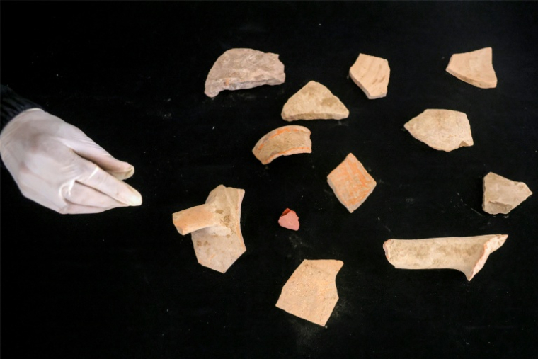 Une membre de l'association Mayasem pour la culture et les arts examine des tessons de poterie, dans le dépôt de patrimoine culturel à Khan Younès, dans le sud de la bande de Gaza, le 11 juillet 2026 ( AFP / Bashar Taleb )
