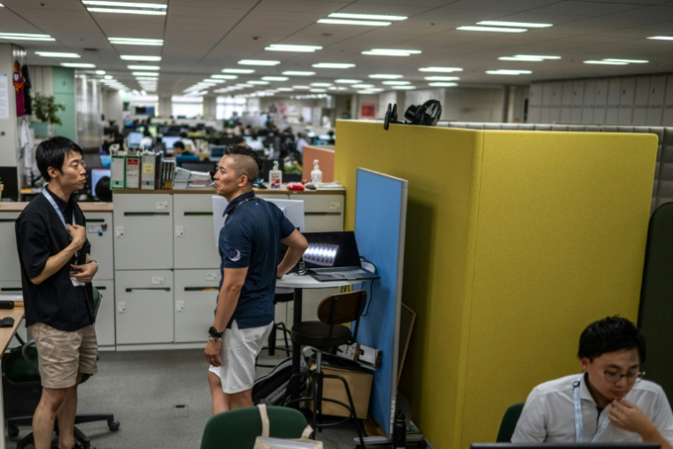 Des fonctionnaires en shorts, t-shirt et baskets, dans les bureaux du siège du gouvernement métropolitain de Tokyo,dans le cadre de l'initiative "Cool Biz" le 14 juillet 2026 lors d'une vague de fortes chaleurs ( AFP / Philip FONG )