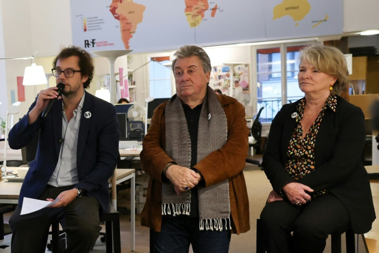 De gauche à droite le directeur général de RSF Thibaut Bruttin, le beau-père et la mère de Christophe Gleizes, Francis et Sylvie Godard, à Paris le 15 octobre 2026 ( AFP / Anne-Christine POUJOULAT )