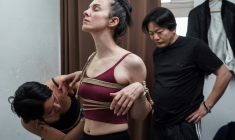 Une jeune femme attache les bras de sa modèle sous les yeux de Hajime Kinoko, l'un des plus connus artistes japonais de "shibari", l'art des cordes, le 26 mai 2025 à Tokyo ( AFP / Caroline GARDIN )