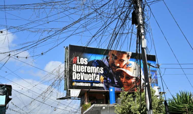 Un panneau d'affichage montrant une photo de l'ancien président vénézuélien Nicolas Maduro et de son épouse, Cilia Flores, dans le quartier de Petare à Caracas, le 14 mai 2026 ( AFP / Juan BARRETO )