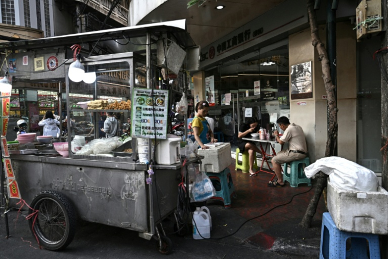 Des gens attablés dans un restaurant de rue, le 29 avril 2026 à Bangkok  ( AFP / Lillian SUWANRUMPHA )