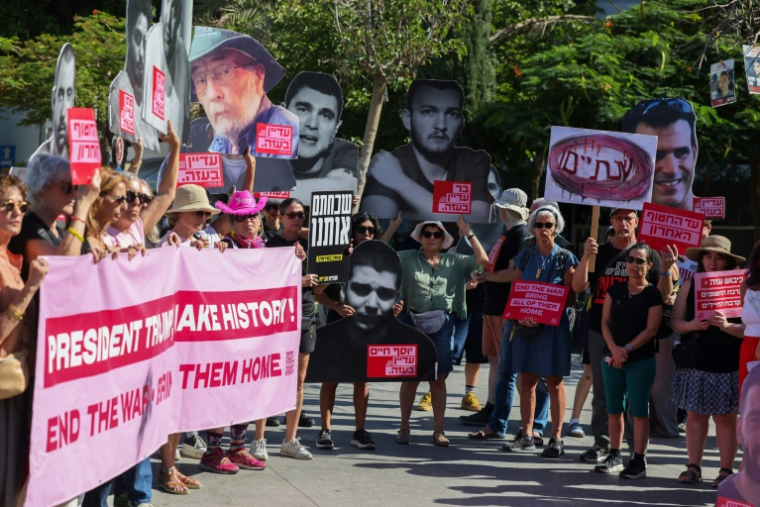 Des Israéliens brandissent des pancartes et des portraits d'otages retenus dans la bande de Gaza, lors d'un rassemblement à Tel-Aviv marquant le deuxième anniversaire de l'attaque du Hamas, le 7 octobre 2025 ( AFP / Ahmad GHARABLI )