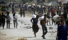 Des Palestiniens transportent des sacs d'aide humanitaire, dans le camp de Nousseirat, dans le centre de la bande de Gaza, le 27 juillet 2025 ( AFP / Eyad BABA )